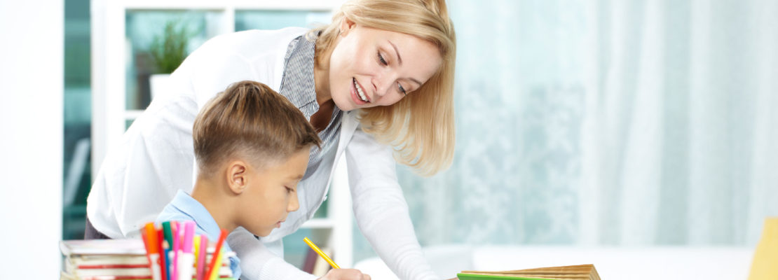 Portrait of smart tutor with pencil correcting mistakes in pupils notebook